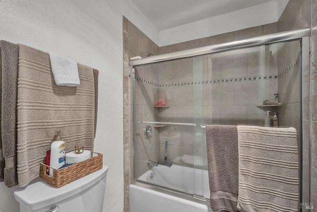 full bathroom featuring toilet and combined bath / shower with glass door