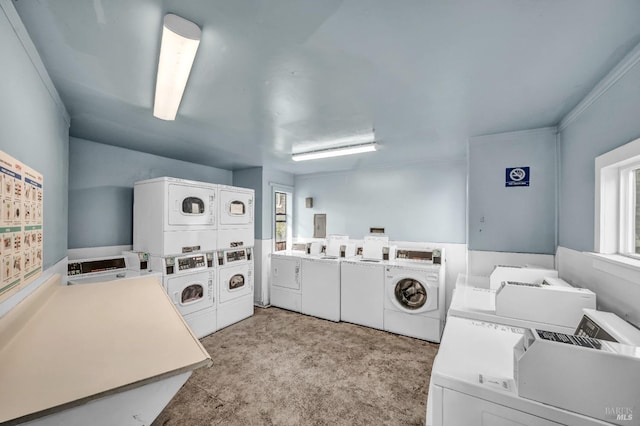 common laundry area with stacked washing maching and dryer, washer and dryer, and a healthy amount of sunlight