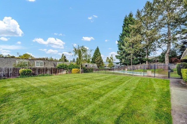 view of yard with fence and a fenced in pool