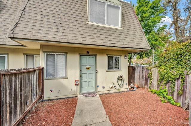 view of front of property with a shingled roof and a fenced backyard