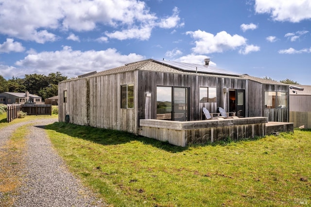 360 Grey Whale, The Sea Ranch, CA 95497 - back of property with roof mounted solar panels, fence, a yard, and driveway