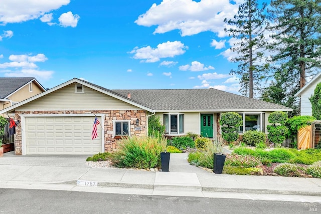 single story home featuring a garage, roof with shingles, stone siding, and concrete driveway