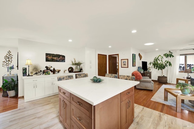 kitchen featuring light countertops, a center island, recessed lighting, and light wood-style flooring