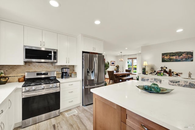 kitchen with light countertops, stainless steel appliances, recessed lighting, and white cabinetry