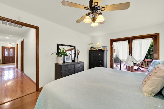 bedroom featuring ceiling fan, baseboards, visible vents, and wood finished floors