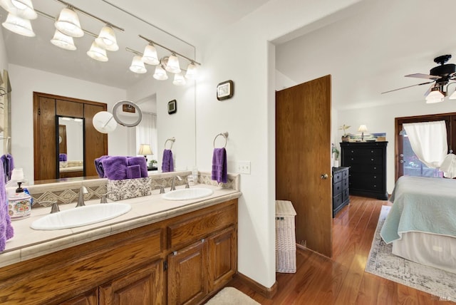 ensuite bathroom featuring a ceiling fan, a sink, ensuite bathroom, and wood finished floors