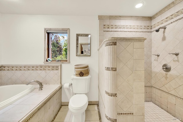 full bath with tile patterned flooring, a garden tub, toilet, baseboards, and tiled shower