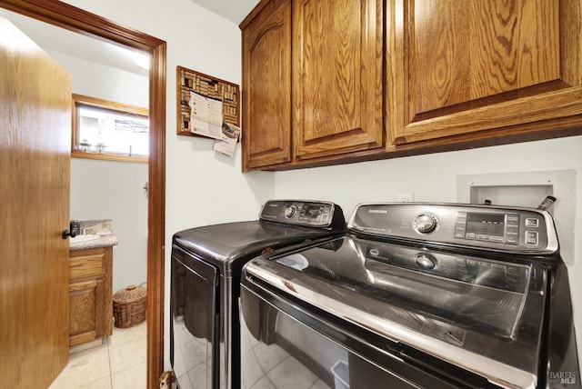 laundry room with light tile patterned floors, cabinet space, and independent washer and dryer