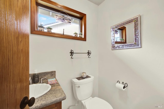 half bath featuring toilet and vanity