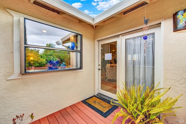 doorway to property featuring stucco siding