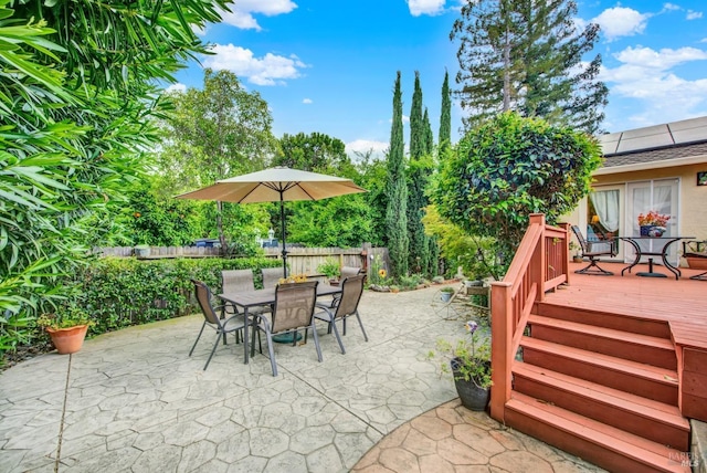 view of patio / terrace with outdoor dining area, a fenced backyard, and a deck