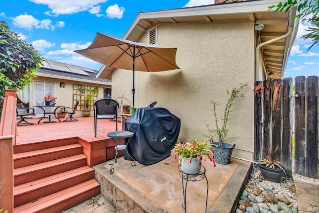 deck featuring fence, outdoor dining area, and a grill