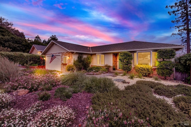 single story home featuring a garage and stone siding