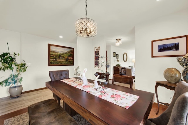 dining room with baseboards, recessed lighting, wood finished floors, and a notable chandelier