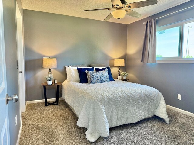 carpeted bedroom featuring a ceiling fan, baseboards, and a textured ceiling