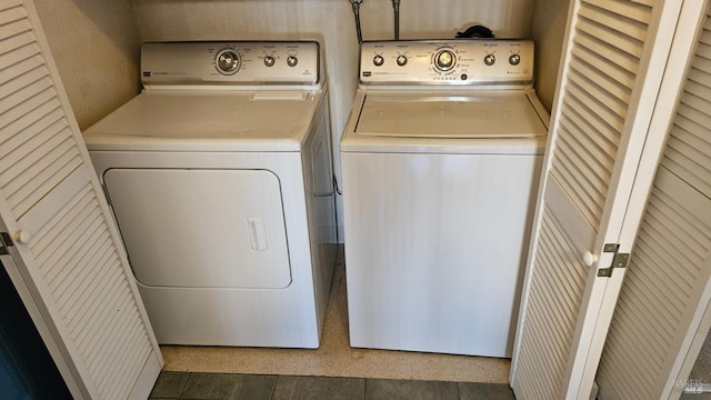clothes washing area featuring separate washer and dryer and laundry area