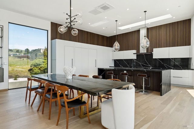 dining room featuring recessed lighting, light wood finished floors, visible vents, and a skylight
