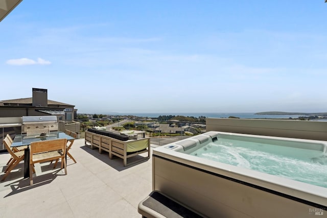 view of patio with outdoor dining space, exterior kitchen, and an outdoor hot tub