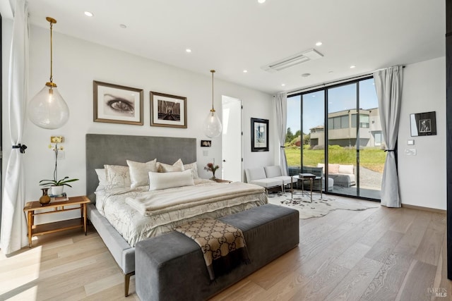 bedroom featuring expansive windows, light wood finished floors, access to outside, and visible vents