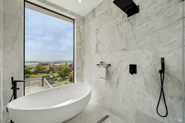 bathroom featuring tile walls and a soaking tub