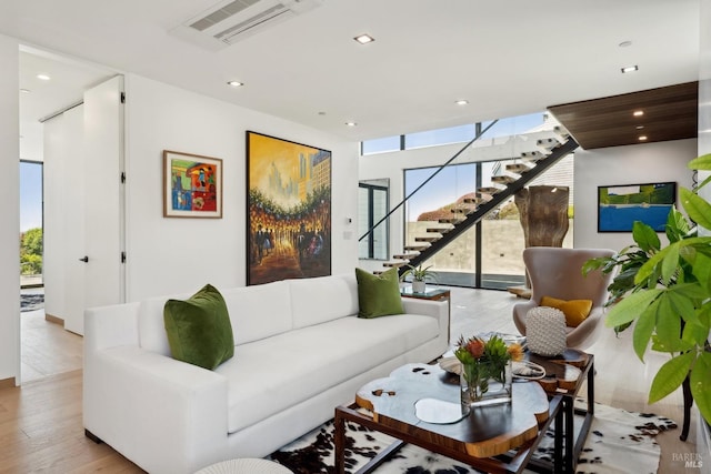 living room with stairway, recessed lighting, light wood-type flooring, and visible vents