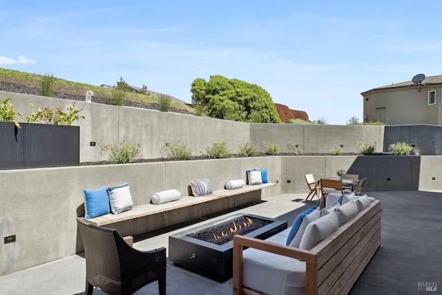 view of patio with fence and an outdoor living space with a fire pit