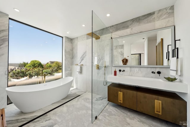 full bathroom featuring vanity, marble finish floor, a freestanding bath, a marble finish shower, and backsplash
