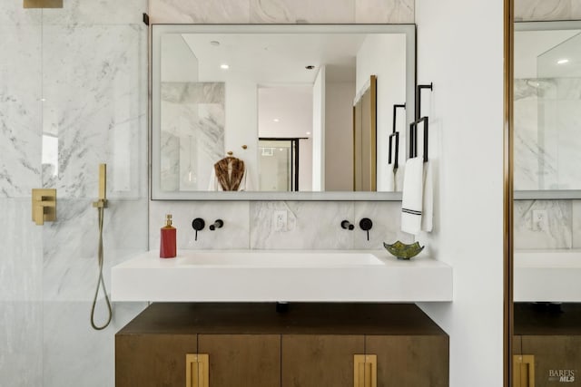 full bathroom featuring vanity, a marble finish shower, and tasteful backsplash