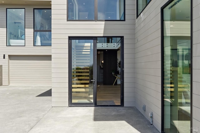 entrance to property with concrete driveway and an attached garage