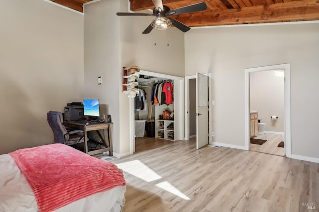 bedroom with wood finished floors, baseboards, and ensuite bathroom