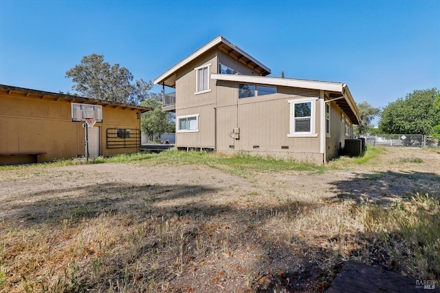 rear view of property featuring crawl space and central AC