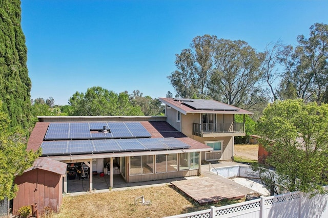 rear view of property with solar panels, a sunroom, and a fenced backyard