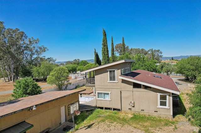view of side of property with a balcony, a mountain view, and crawl space