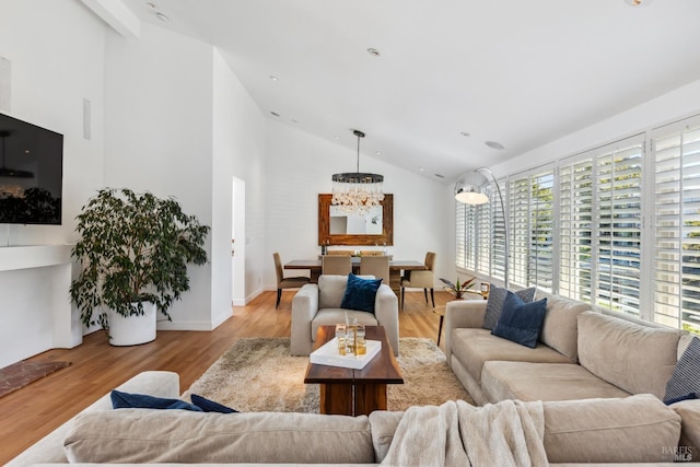 living area with wood finished floors, a chandelier, and high vaulted ceiling
