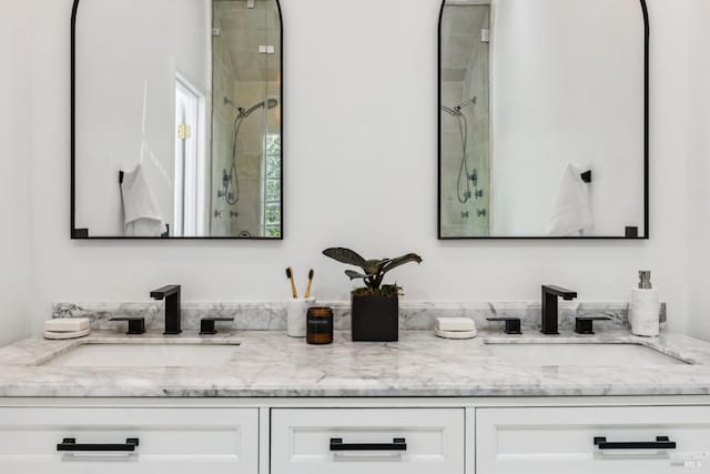 full bath with a sink, a shower stall, and double vanity