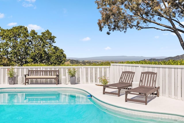 view of swimming pool featuring a fenced in pool and a mountain view