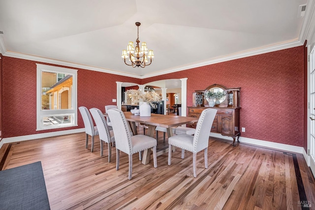 dining area featuring an inviting chandelier, baseboards, wallpapered walls, decorative columns, and wood finished floors
