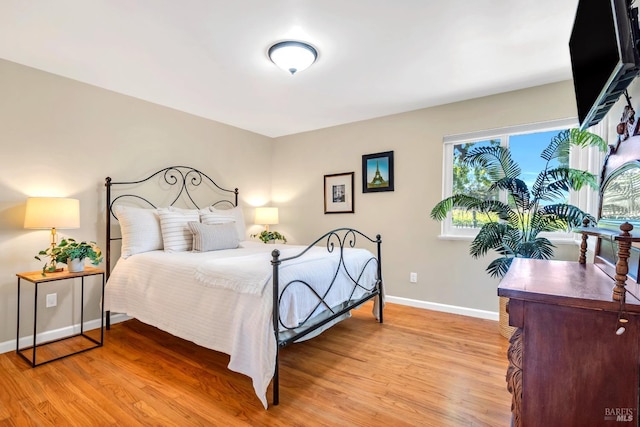 bedroom featuring light wood-type flooring and baseboards