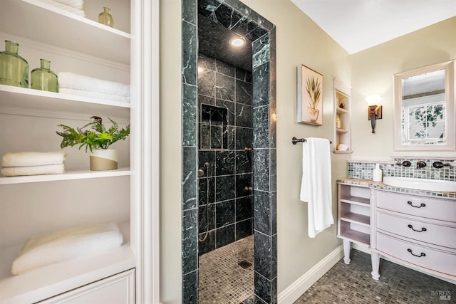bathroom with vanity, baseboards, and walk in shower