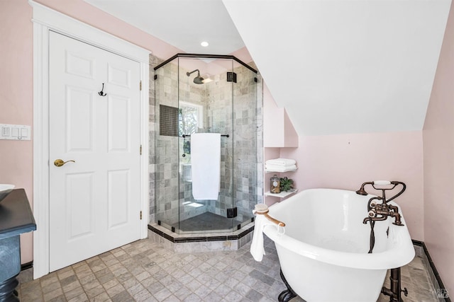 bathroom with recessed lighting, vaulted ceiling, a soaking tub, and a stall shower