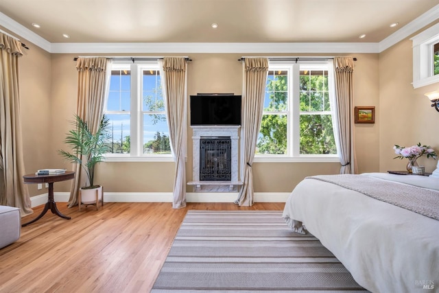 bedroom featuring baseboards, a glass covered fireplace, and multiple windows