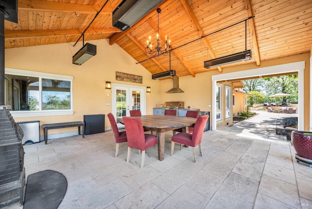 dining space featuring an inviting chandelier, plenty of natural light, french doors, and stone tile flooring