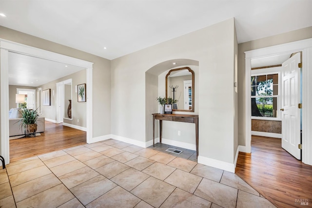 hall with visible vents, arched walkways, wood finished floors, baseboards, and recessed lighting