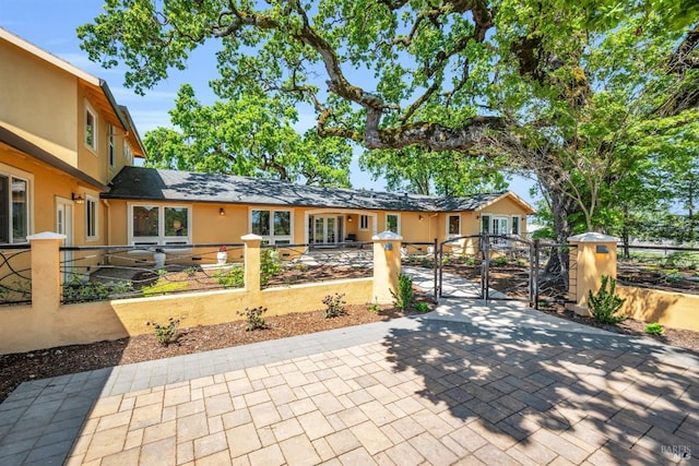 view of front of property with a fenced front yard, a gate, and stucco siding