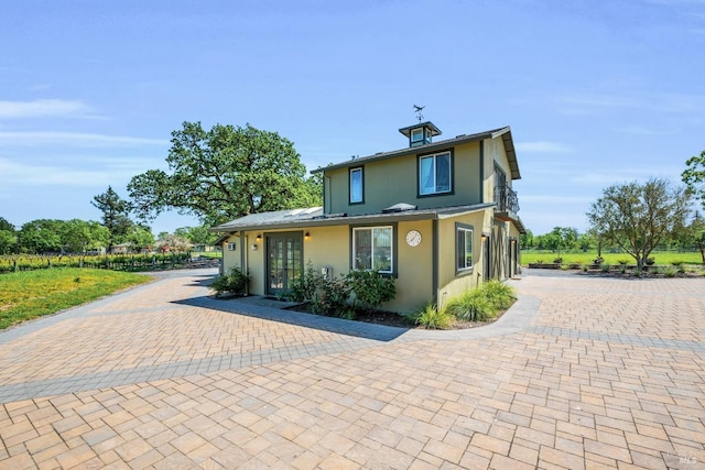 view of front of house with french doors and stucco siding