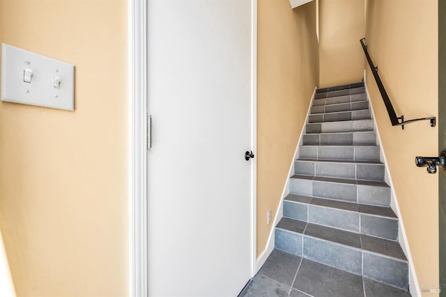 stairs with baseboards and tile patterned flooring