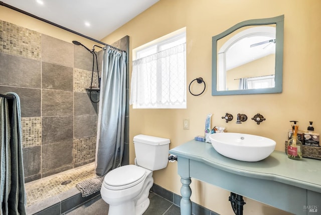 full bathroom with a tile shower, toilet, a healthy amount of sunlight, and a sink