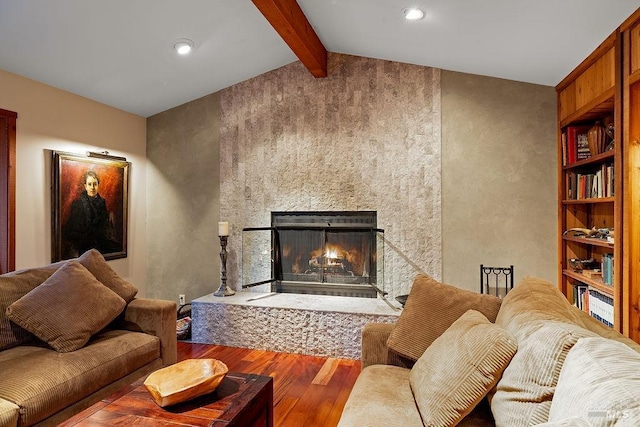 living room featuring lofted ceiling with beams, wood finished floors, and a fireplace