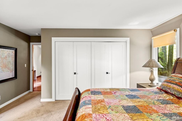 carpeted bedroom with baseboards and a closet