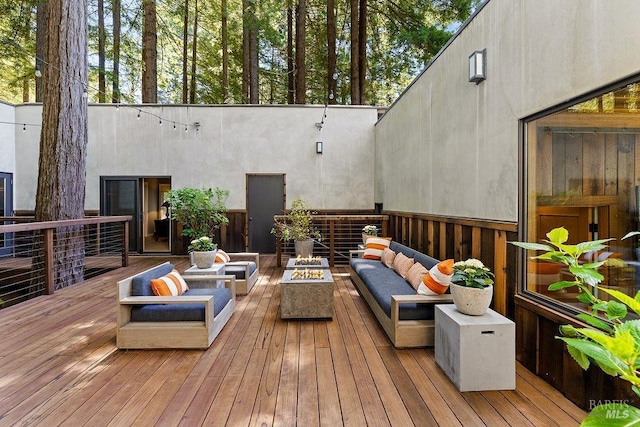 deck with an outdoor living space with a fire pit